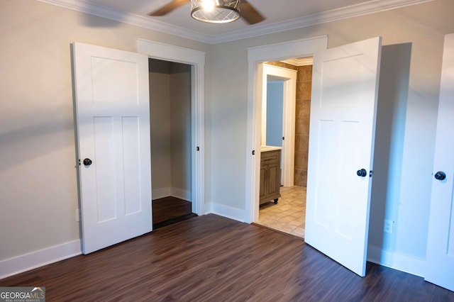 unfurnished bedroom featuring ornamental molding, a ceiling fan, connected bathroom, wood finished floors, and baseboards