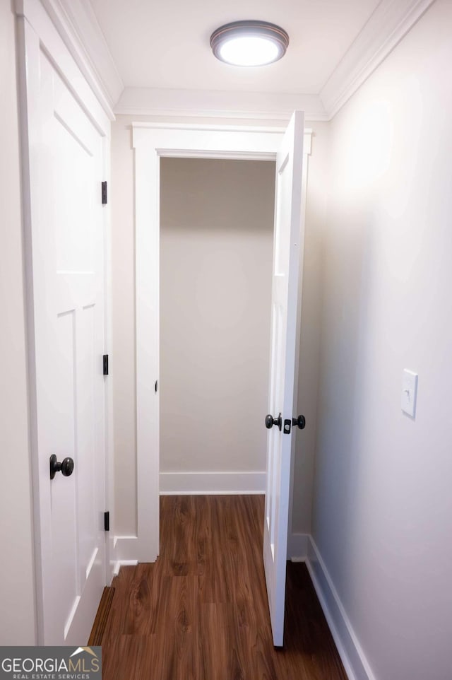 hallway featuring crown molding, baseboards, and wood finished floors