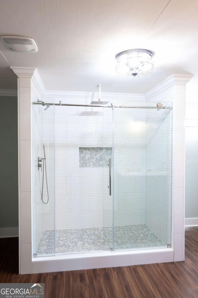 full bath featuring a stall shower, visible vents, crown molding, and wood finished floors