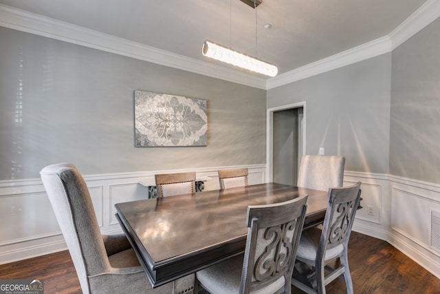 dining space with wainscoting, crown molding, and wood finished floors