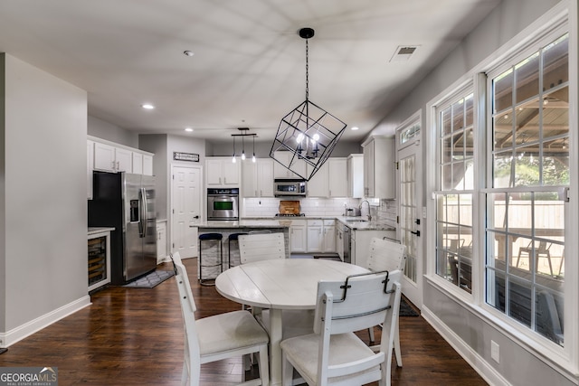 dining area featuring visible vents, wine cooler, dark wood-type flooring, and baseboards