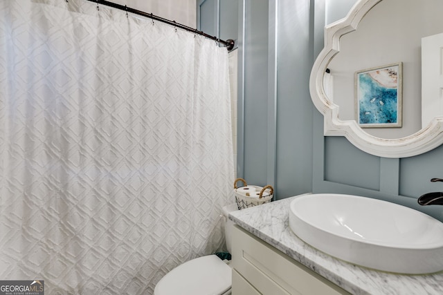 bathroom with toilet, curtained shower, and vanity