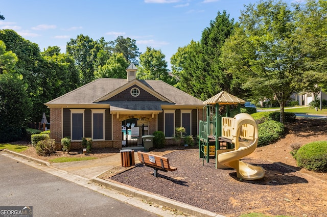 exterior space with brick siding and a playground