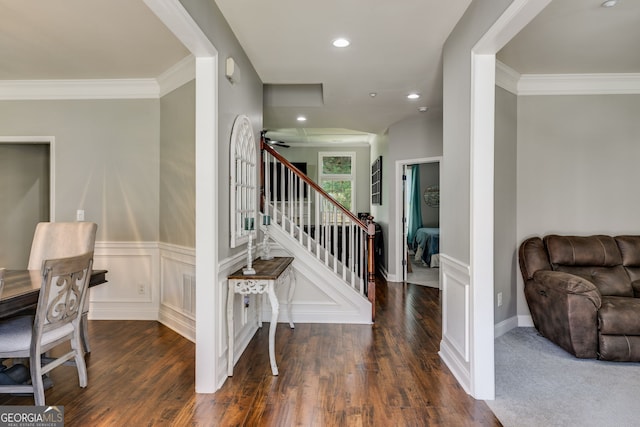 foyer entrance with stairs, wood finished floors, wainscoting, and ornamental molding