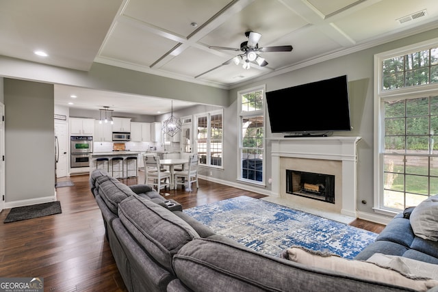 living area with dark wood finished floors, visible vents, and coffered ceiling