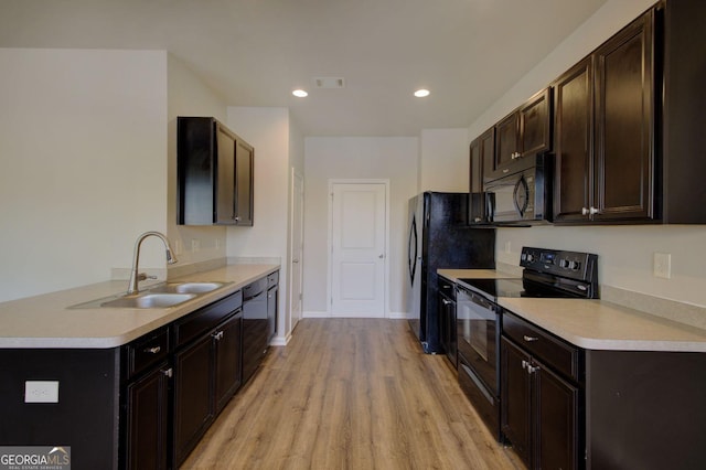 kitchen with light countertops, visible vents, a sink, and black appliances