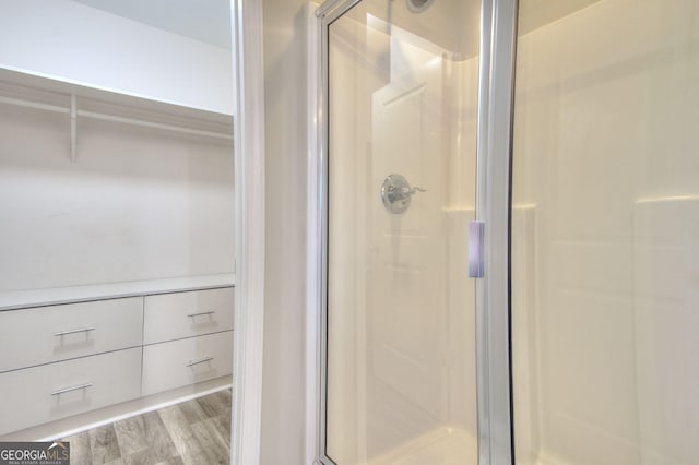 bathroom featuring a shower stall and wood finished floors