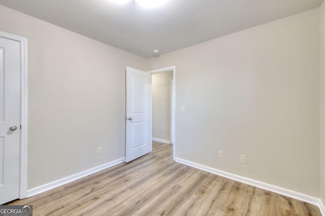 empty room with light wood-style floors and baseboards