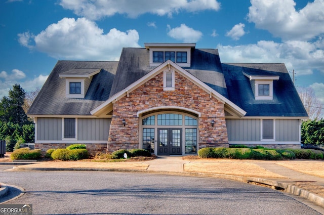 view of front of property with stone siding, board and batten siding, and french doors