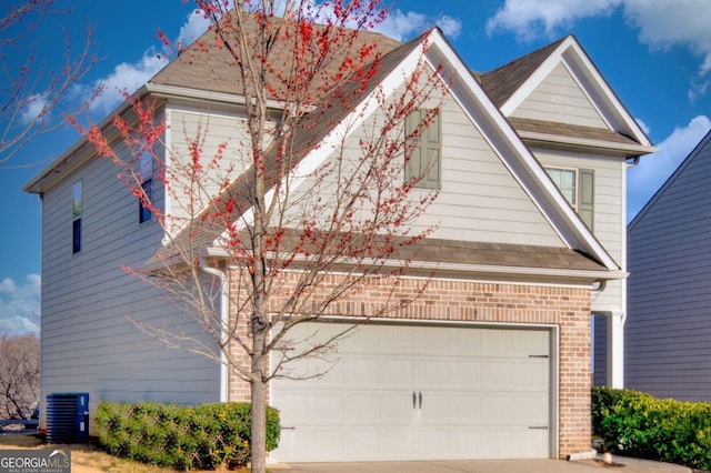 view of front facade featuring a garage, concrete driveway, central AC, and brick siding