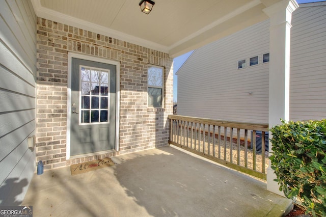 doorway to property featuring a patio area and brick siding