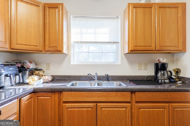 kitchen with dark countertops, brown cabinets, and a sink