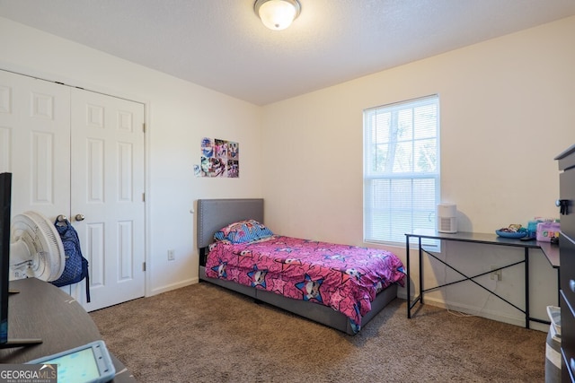 bedroom with a closet, carpet flooring, and baseboards