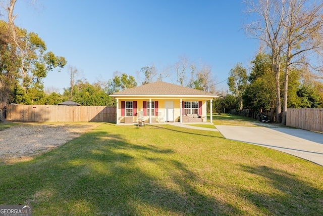 view of front of home featuring driveway, a front yard, and fence