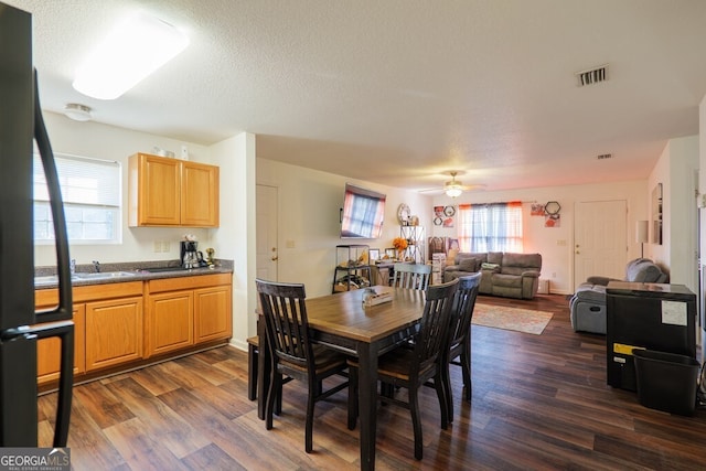 dining area featuring dark wood-style floors, ceiling fan, a textured ceiling, and visible vents