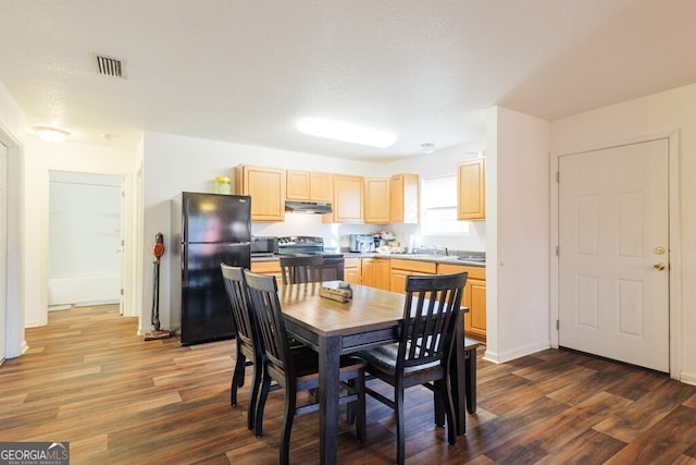 dining space with dark wood-style floors, visible vents, and baseboards