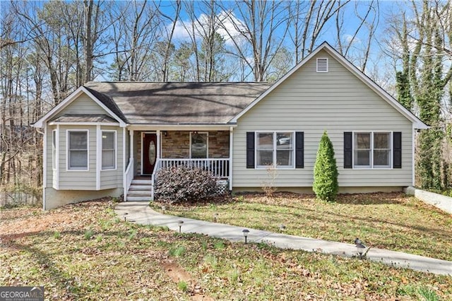 ranch-style home with covered porch, stone siding, and a front lawn