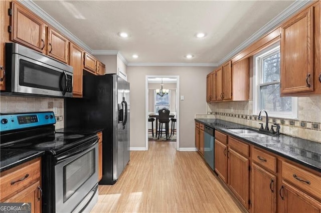 kitchen with ornamental molding, appliances with stainless steel finishes, and brown cabinets