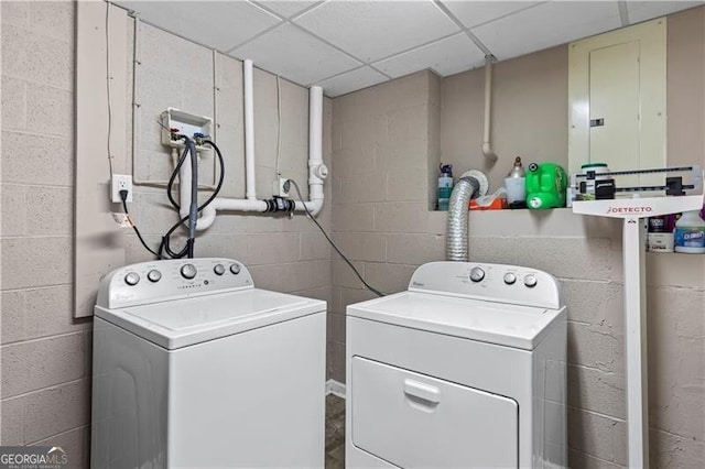 laundry area with laundry area, independent washer and dryer, concrete block wall, and electric panel