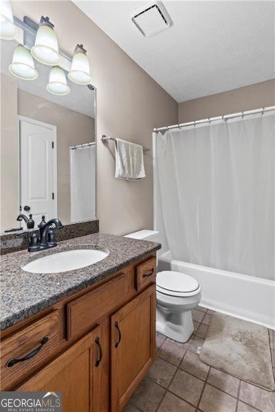 full bath featuring toilet, vanity, visible vents, tile patterned floors, and shower / bath combo