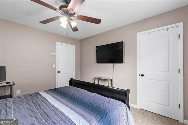 carpeted bedroom with ceiling fan and baseboards