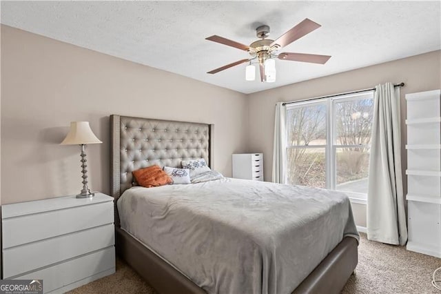 bedroom featuring carpet floors, ceiling fan, and a textured ceiling