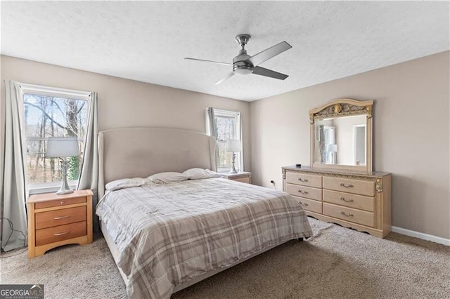 bedroom with a textured ceiling, ceiling fan, baseboards, and light colored carpet