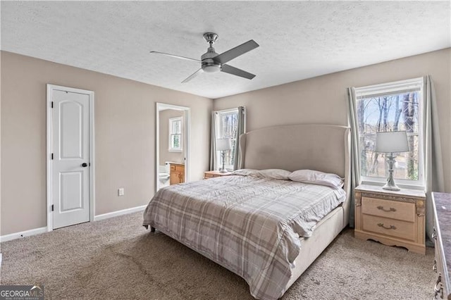 bedroom with a textured ceiling, ceiling fan, light carpet, baseboards, and ensuite bath