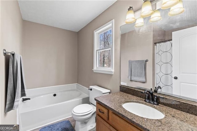 full bathroom featuring toilet, a garden tub, and vanity