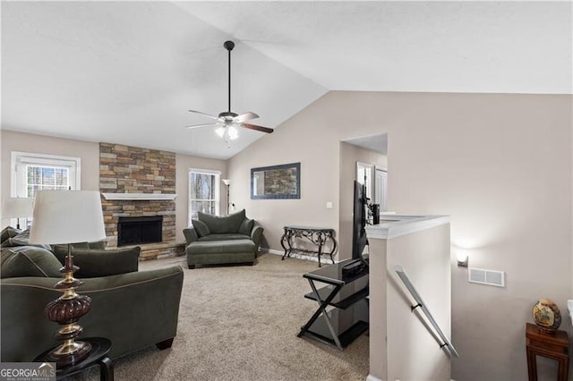 carpeted living room with lofted ceiling, baseboards, visible vents, and a stone fireplace