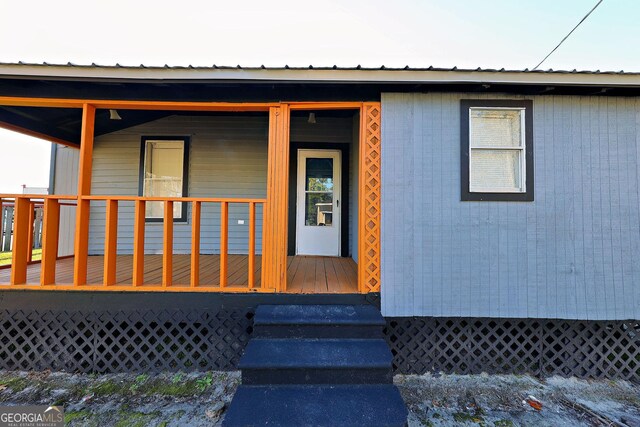 property entrance featuring covered porch and metal roof