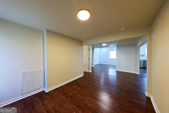 spare room featuring dark wood-style floors, baseboards, and visible vents