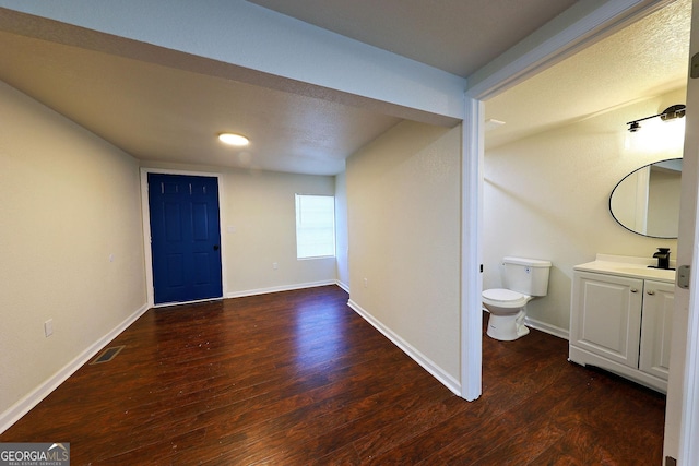 entryway featuring visible vents, baseboards, and wood finished floors