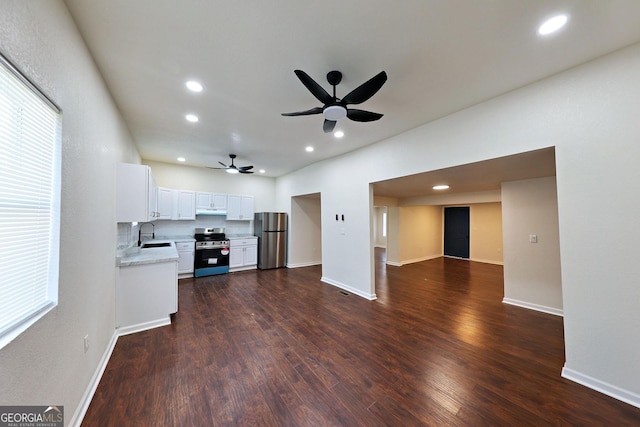 kitchen featuring dark wood finished floors, stainless steel appliances, light countertops, under cabinet range hood, and recessed lighting