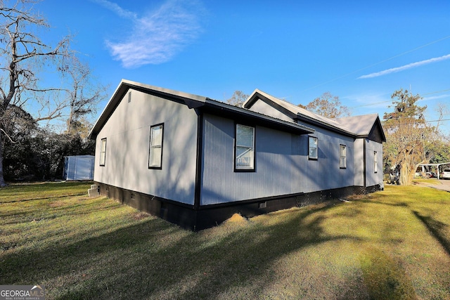 view of side of home with a yard and crawl space