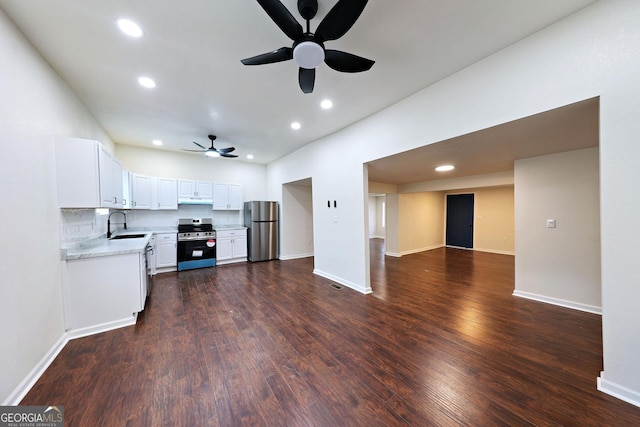 kitchen with under cabinet range hood, dark wood-style flooring, a sink, light countertops, and appliances with stainless steel finishes