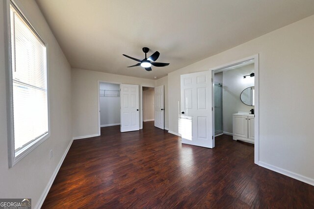 unfurnished bedroom featuring ceiling fan, baseboards, and dark wood finished floors