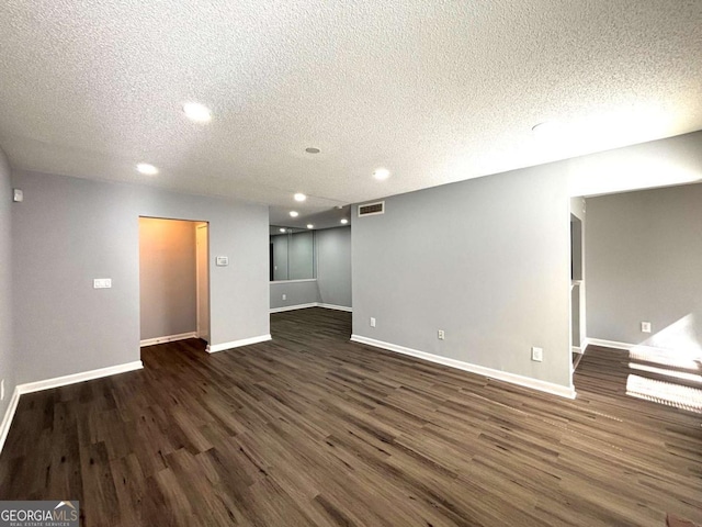 interior space featuring baseboards, dark wood finished floors, and a textured ceiling