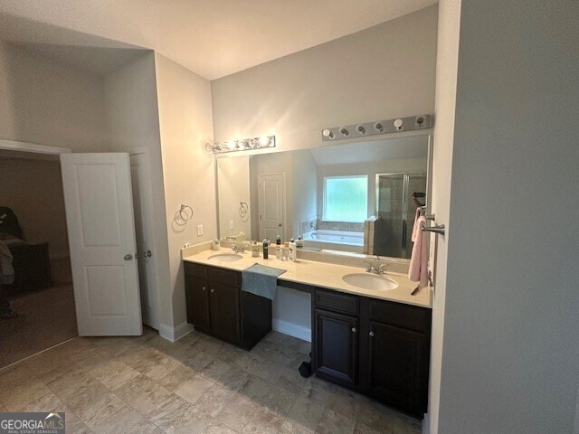 bathroom with a bath, a stall shower, double vanity, and a sink