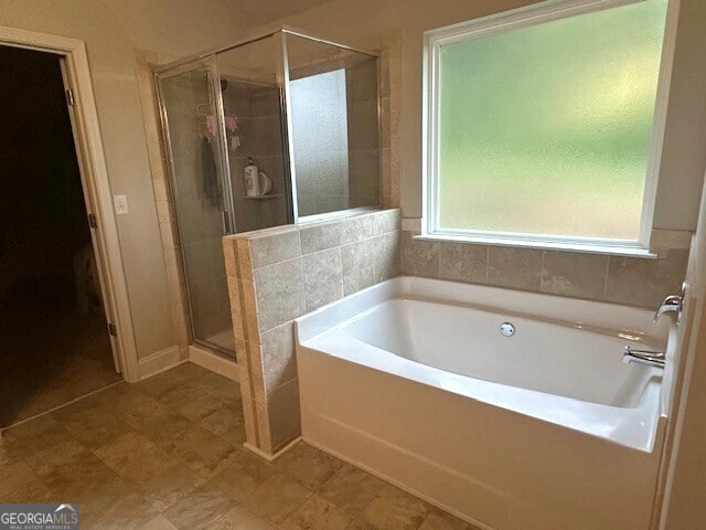 bathroom featuring a bath and a shower stall