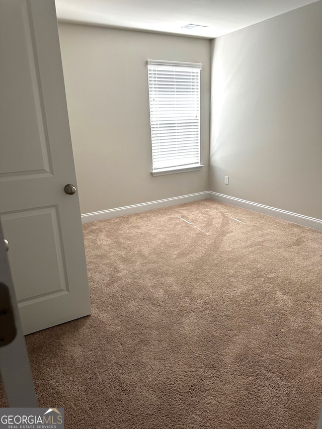 spare room featuring baseboards and carpet