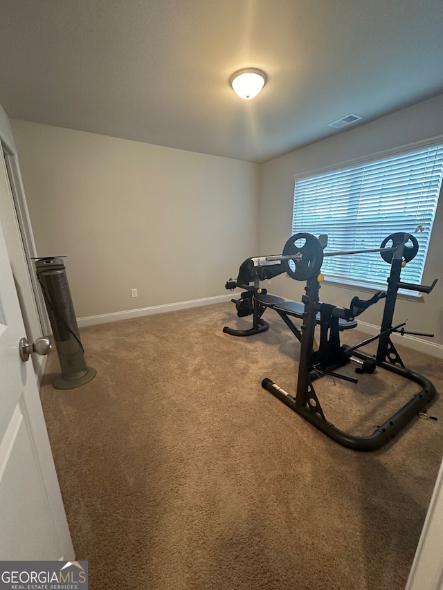 workout area featuring visible vents, baseboards, and carpet floors