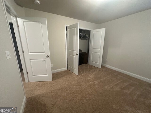 unfurnished bedroom with a closet, baseboards, and carpet floors