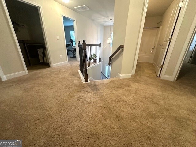 corridor with carpet flooring, an upstairs landing, and baseboards