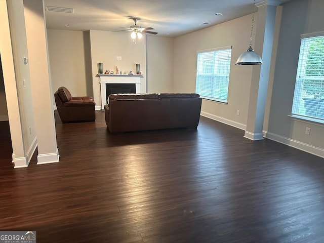 unfurnished living room featuring visible vents, dark wood-style floors, a fireplace, and baseboards