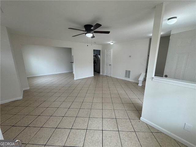 unfurnished room with light tile patterned floors, ceiling fan, visible vents, and baseboards