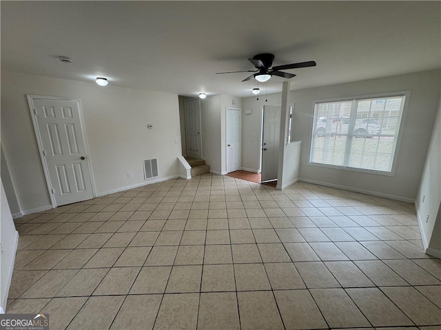 unfurnished room featuring light tile patterned floors, baseboards, visible vents, and ceiling fan