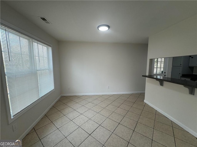 interior space featuring baseboards, visible vents, and a wealth of natural light