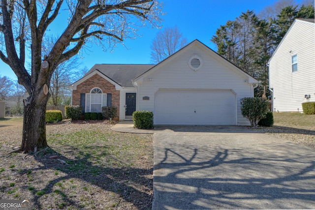 single story home featuring an attached garage, aphalt driveway, and brick siding