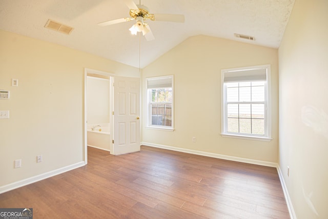 unfurnished bedroom featuring multiple windows, visible vents, and wood finished floors